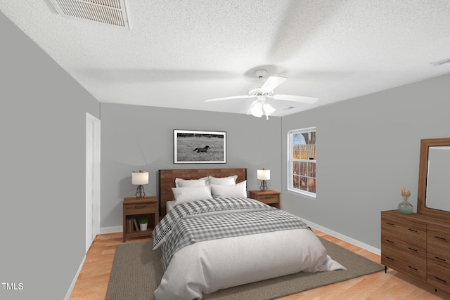 bedroom featuring wood-type flooring, a textured ceiling, and ceiling fan