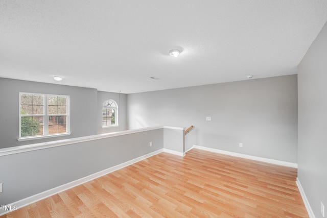 spare room featuring light hardwood / wood-style flooring and a textured ceiling