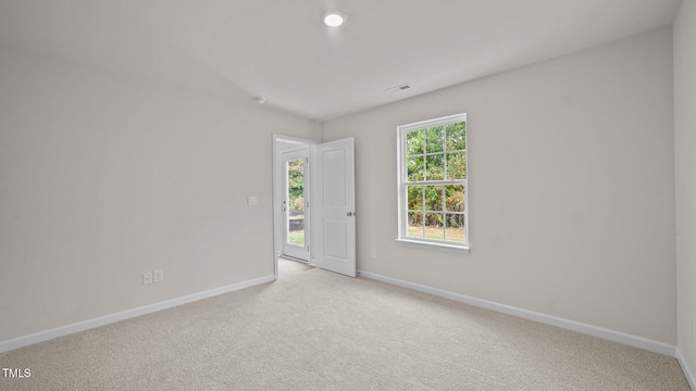 spare room featuring light carpet