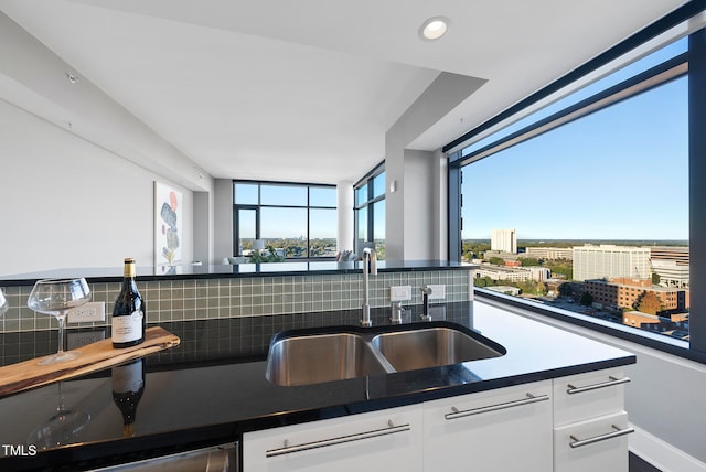 kitchen featuring white cabinets, backsplash, and sink