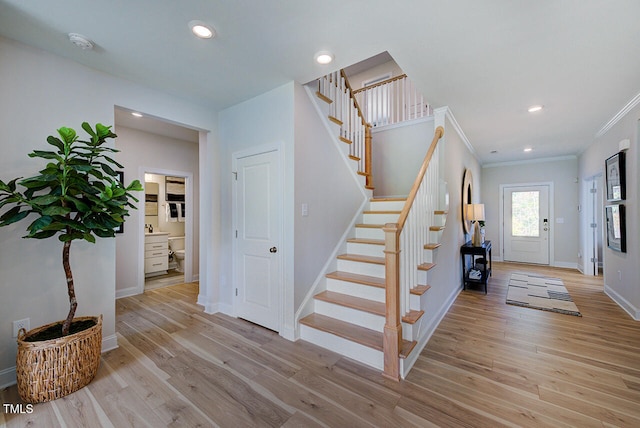 entryway with light wood-type flooring and ornamental molding