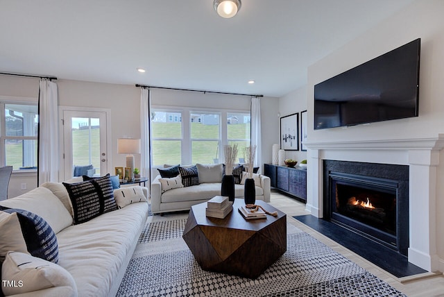 904 Delano Dr, Knightdale, NC 27545 - living room featuring plenty of natural light, a warm lit fireplace, wood finished floors, and recessed lighting
