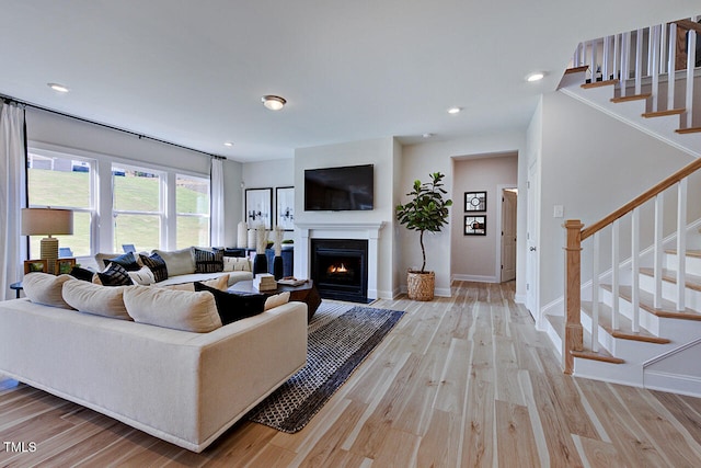 904 Delano Dr, Knightdale, NC 27545 - living room with light wood-style flooring, a fireplace with flush hearth, stairway, and recessed lighting