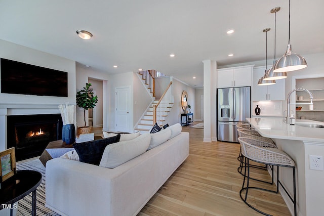 904 Delano Dr, Knightdale, NC 27545 - living room featuring light wood-type flooring, stairway, a lit fireplace, recessed lighting, and baseboards