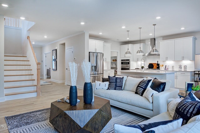 living room with light hardwood / wood-style floors and ornamental molding