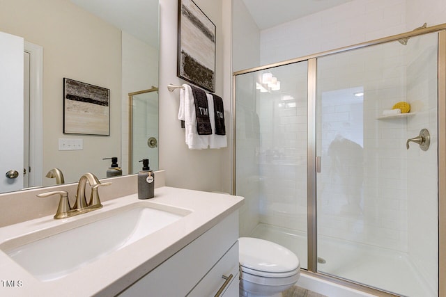 bathroom with vanity, an enclosed shower, and toilet