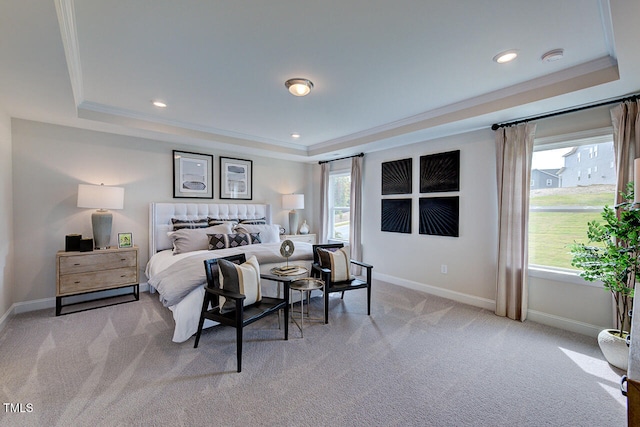 bedroom with light colored carpet, a tray ceiling, and ornamental molding