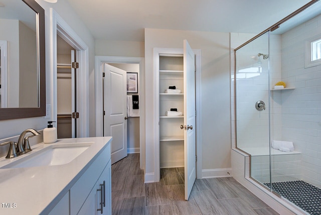 904 Delano Dr, Knightdale, NC 27545 - bathroom with a shower stall, a spacious closet, vanity, and baseboards