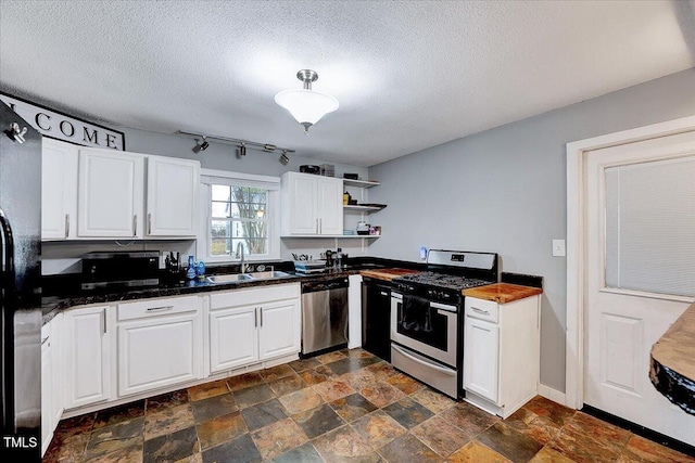 kitchen featuring a textured ceiling, sink, white cabinetry, and stainless steel appliances