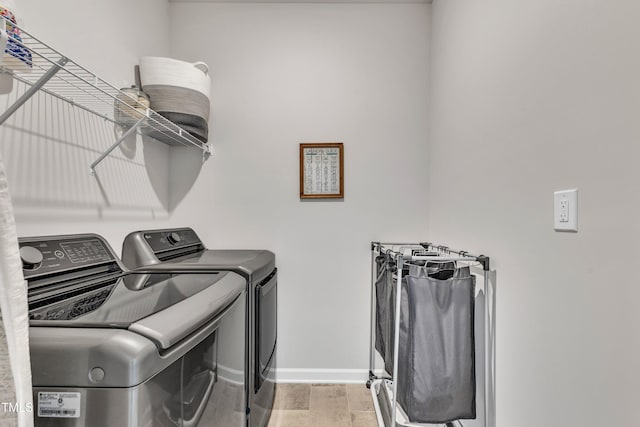 laundry area with independent washer and dryer and light hardwood / wood-style floors