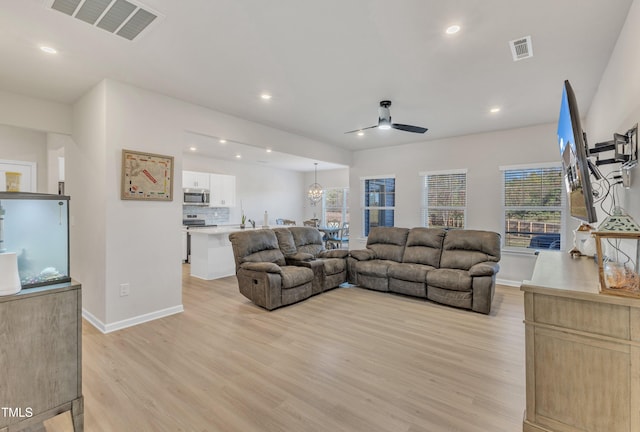 living room featuring light hardwood / wood-style floors, ceiling fan, and a healthy amount of sunlight