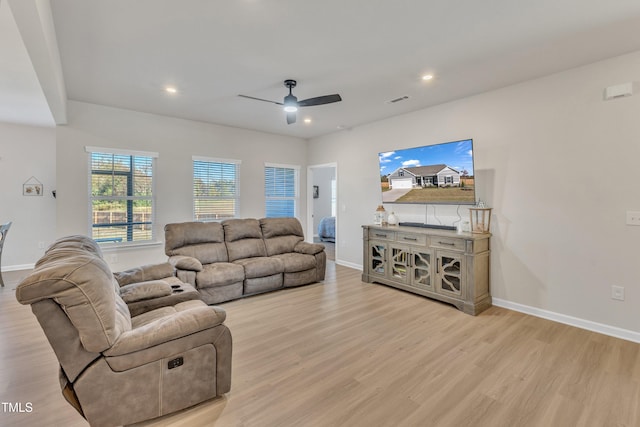 living room featuring light hardwood / wood-style flooring and ceiling fan