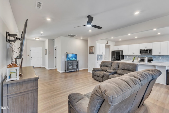 living room featuring ceiling fan and light wood-type flooring