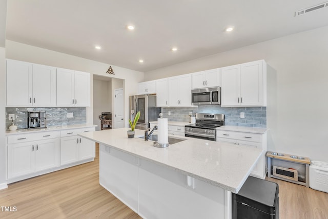 kitchen featuring white cabinetry, a kitchen island with sink, and stainless steel appliances