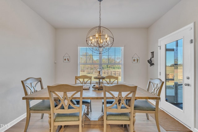 dining space featuring light hardwood / wood-style flooring and a notable chandelier