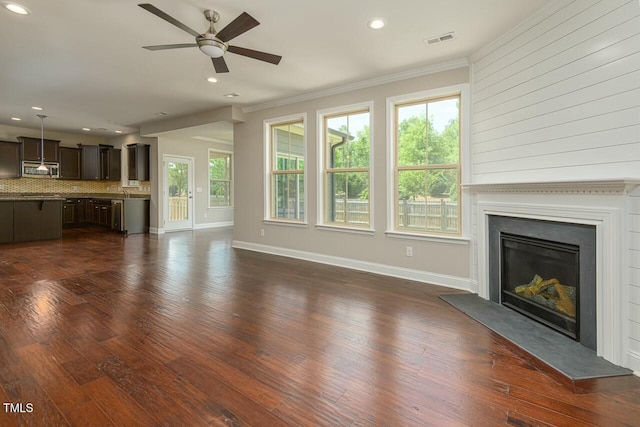 unfurnished living room featuring dark wood-type flooring, ceiling fan, and ornamental molding