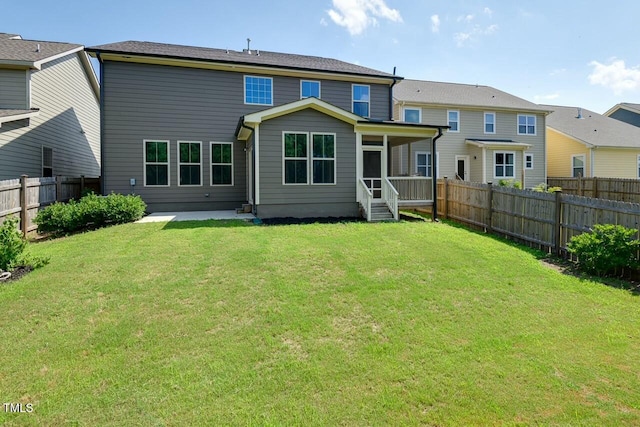 rear view of property featuring a lawn