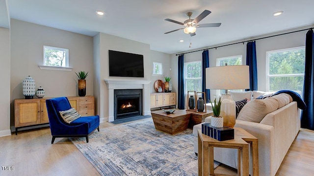 living room featuring ceiling fan, a wealth of natural light, and light hardwood / wood-style floors