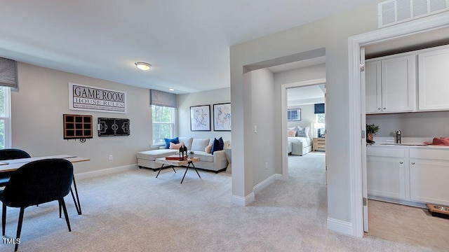 living room featuring sink and light colored carpet