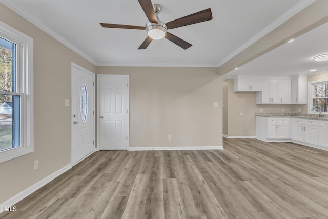 1518 Parks Village Rd, Zebulon, NC 27597 - unfurnished living room with light wood-type flooring, ceiling fan, baseboards, a sink, and crown molding