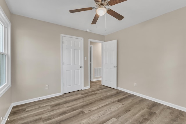 1518 Parks Village Rd, Zebulon, NC 27597 - unfurnished bedroom featuring light hardwood / wood-style floors, multiple windows, and ceiling fan