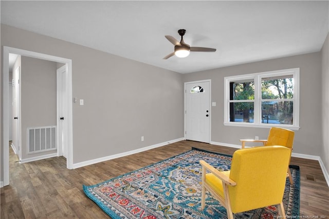 living area with hardwood / wood-style floors and ceiling fan