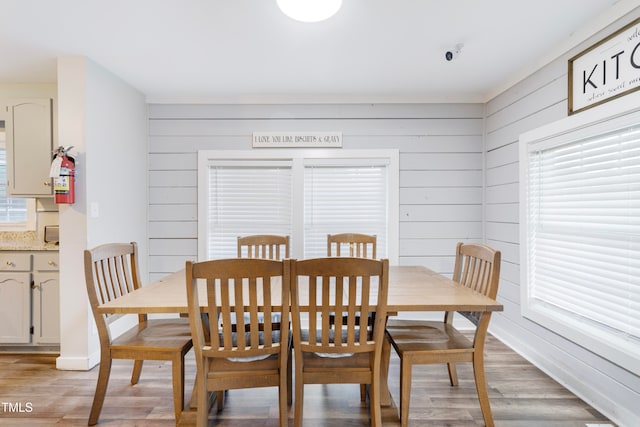 dining room featuring wood walls and light hardwood / wood-style flooring