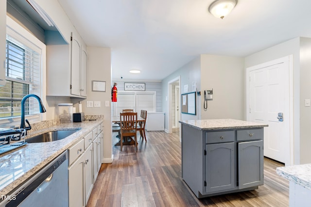 kitchen with dark hardwood / wood-style flooring, sink, dishwasher, a center island, and gray cabinets