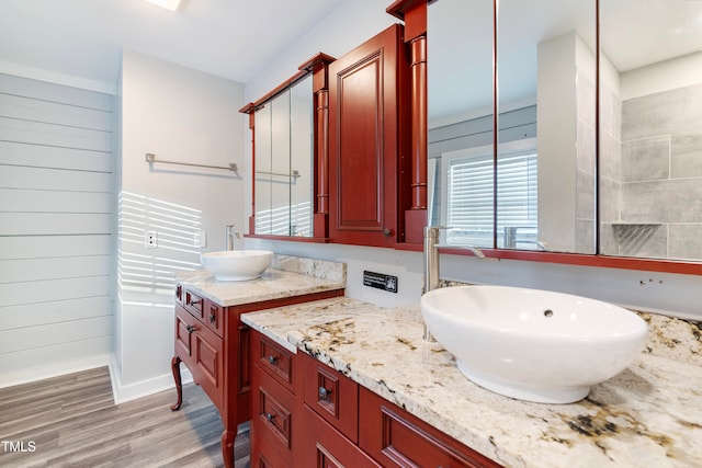 bathroom featuring wooden walls, vanity, and hardwood / wood-style flooring