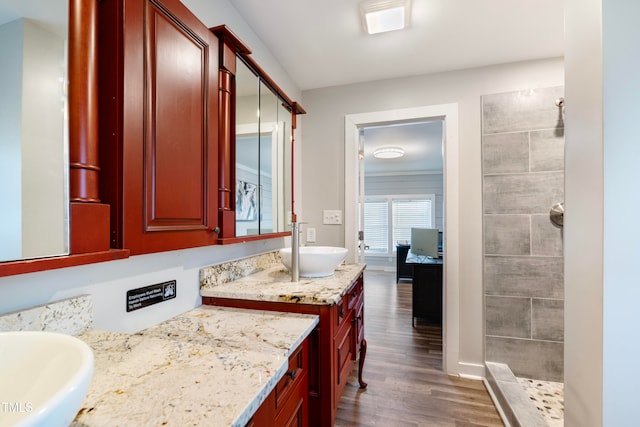 bathroom with vanity, hardwood / wood-style floors, and tiled shower