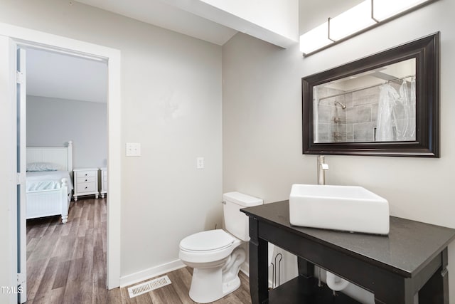 bathroom with vanity, toilet, wood-type flooring, and a shower