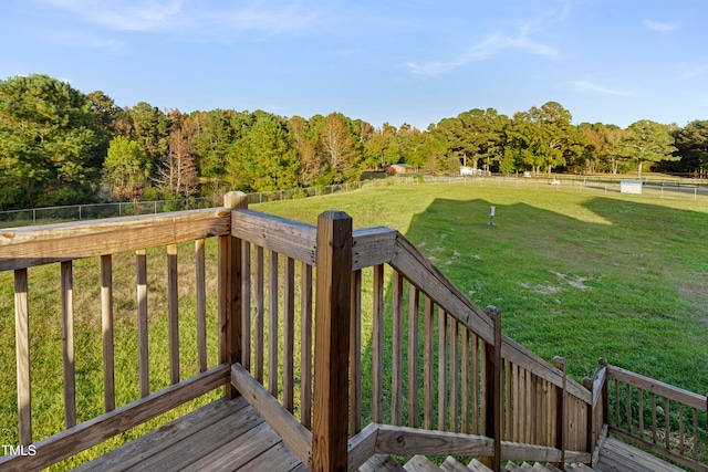 deck with a lawn and a rural view