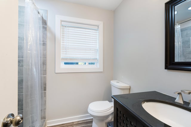 bathroom with a shower with curtain, vanity, wood-type flooring, and toilet