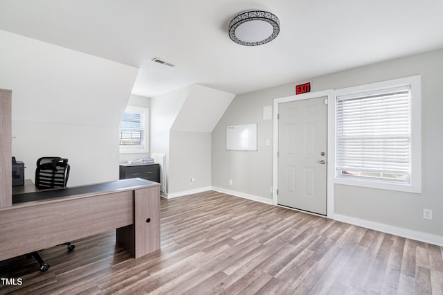 office area with light hardwood / wood-style flooring and vaulted ceiling