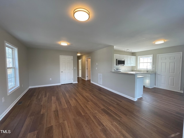 unfurnished living room with dark hardwood / wood-style flooring