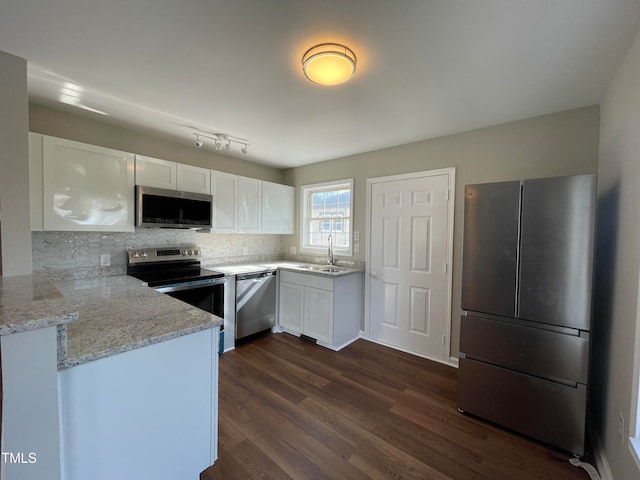 kitchen with dark hardwood / wood-style flooring, tasteful backsplash, appliances with stainless steel finishes, and white cabinets