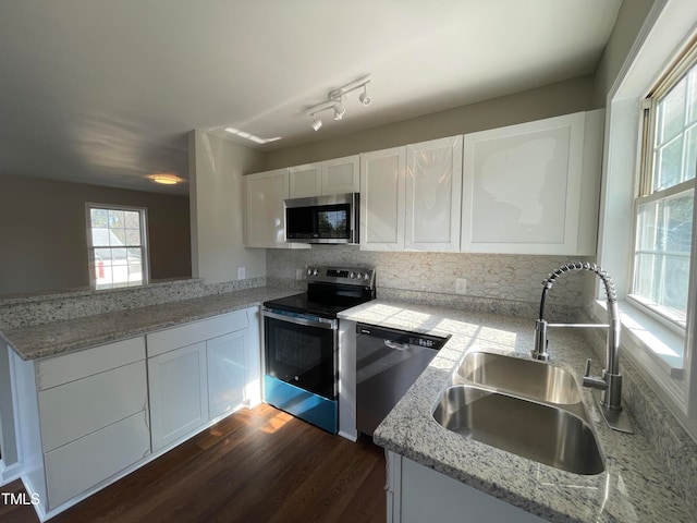 kitchen with stainless steel appliances, white cabinetry, sink, and dark hardwood / wood-style flooring