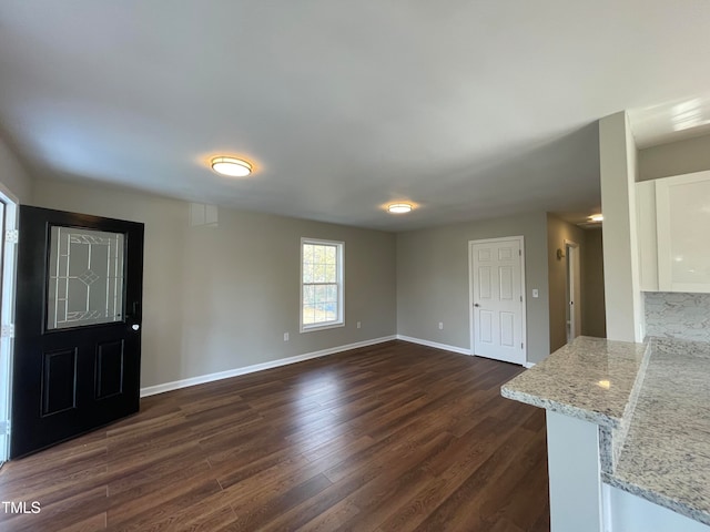 unfurnished living room with dark wood-type flooring