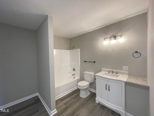 full bathroom with hardwood / wood-style floors, vanity, toilet, and shower / bathing tub combination