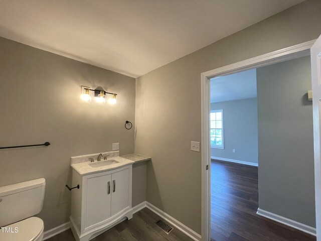 bathroom featuring hardwood / wood-style floors, vanity, and toilet