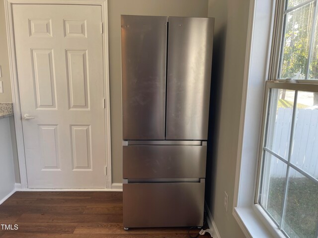 kitchen with dark hardwood / wood-style flooring, a healthy amount of sunlight, and stainless steel fridge