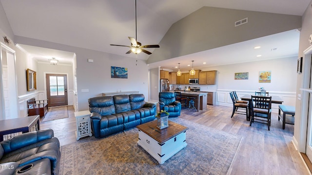 living room featuring hardwood / wood-style floors, high vaulted ceiling, and ceiling fan