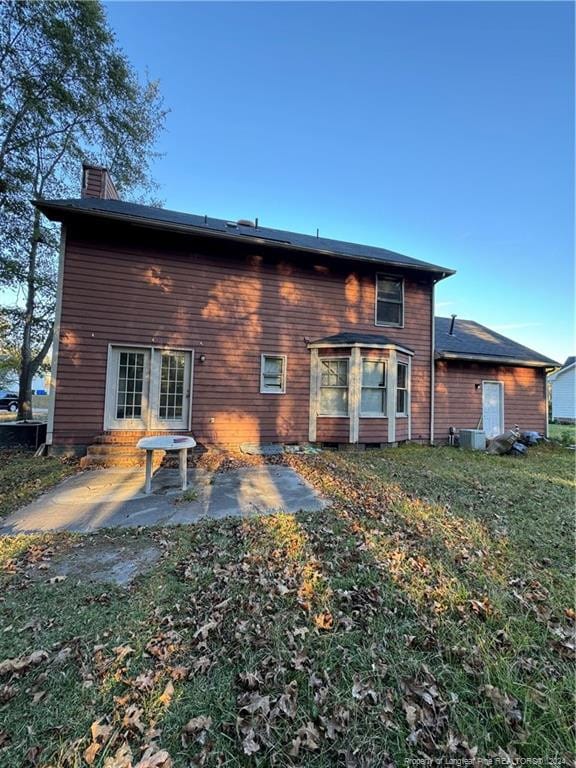 back of house with central AC unit and a patio