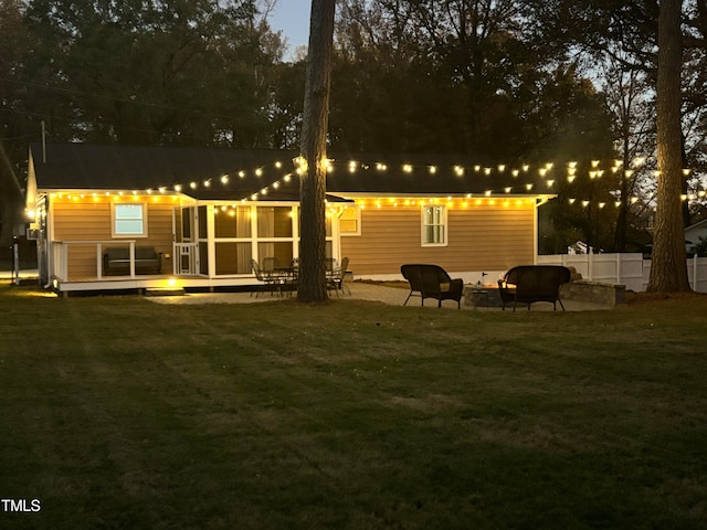 back of property featuring a deck, a patio area, and a lawn