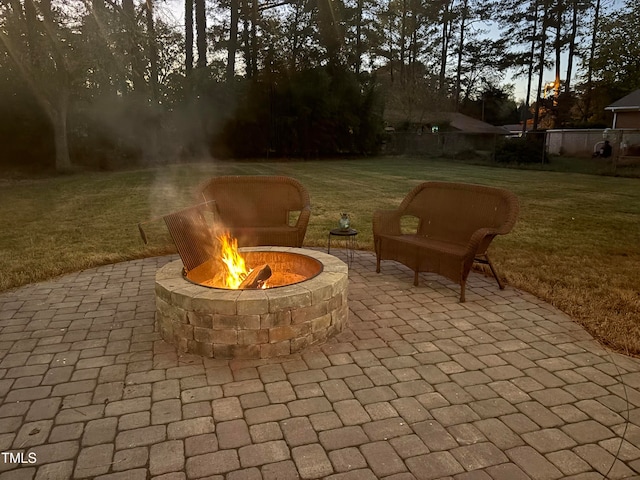 patio terrace at dusk with a yard and an outdoor fire pit