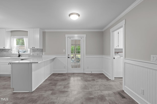 kitchen with tasteful backsplash, kitchen peninsula, a wealth of natural light, and white cabinets