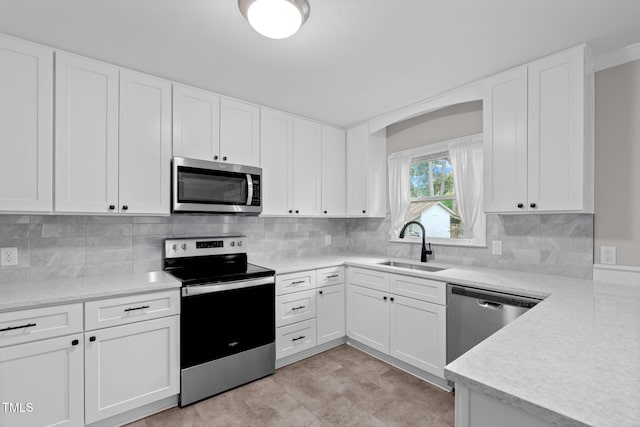 kitchen featuring decorative backsplash, white cabinetry, sink, and appliances with stainless steel finishes