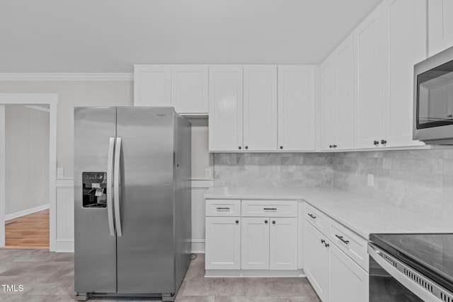 kitchen featuring white cabinets, crown molding, stainless steel appliances, and tasteful backsplash