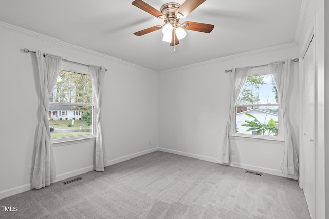 spare room with light carpet, ceiling fan, and ornamental molding