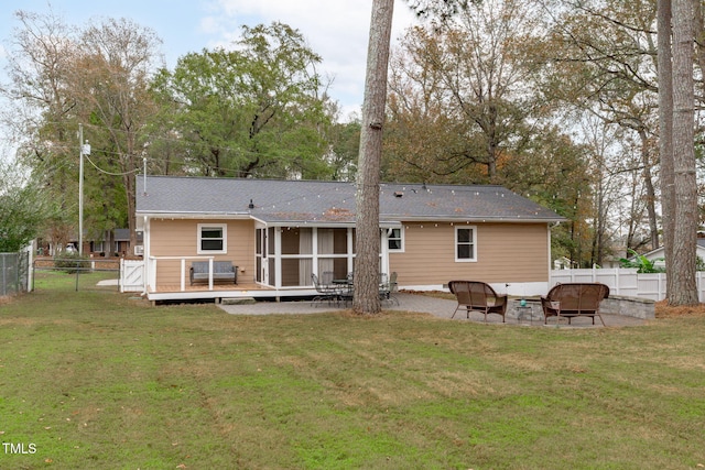 rear view of property featuring a patio, a deck, a sunroom, and a lawn